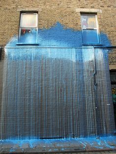 an instagramted photo of a building with blue paint on it