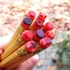 a person holding several pencils in their hand