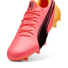 a pink soccer shoe with black detailing on the upper part and yellow soles at the bottom