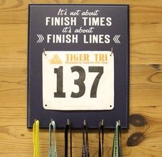 there is a sign that says finish times and some medals hanging on the wall next to it