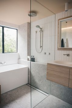 a bathroom with a bathtub, sink and mirror