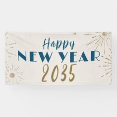 a happy new year banner hanging on a wall with fireworks in the sky behind it