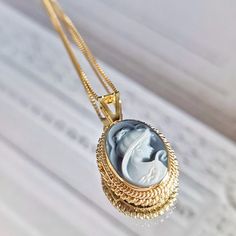 Introducing the SOFIA necklace, Elegant & charming figure to wear close to your heart ♡ Featuring a blue agate cameo necklace framed 18kt gold plated silver sterling 925 textured frame and chain. Total necklace length: 44cm Cameo pendent: 1 X 1.5 cm AVAILABLE ALSO IN SILVER! Check out our Cameo Necklaces section! Design: a lady with long loose hair, gazing romantically. Shape: Oval. Agate is a variety of banded Chalcedony, which is a variety of the mineral Quartz, known for helping you express y Luxury Oval Vintage Necklace, Textured Frame, 18k Gold Necklace, Golden Necklace, Cameo Jewelry, Cameo Necklace, Chain Design, Personalized Gifts For Her, Blue Agate