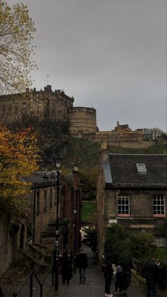 people are walking up and down the stairs in front of some buildings on a cloudy day