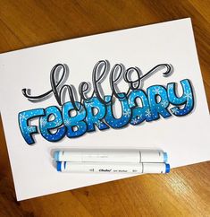 a piece of paper with the words hello february written in blue and white on it