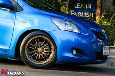 a blue car parked on the side of the road with its front wheel turned sideways