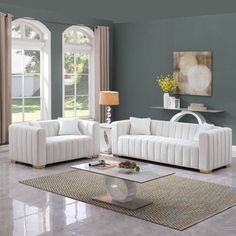 a living room with two white couches and a coffee table