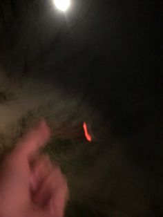 a blurry image of a person pointing at the moon