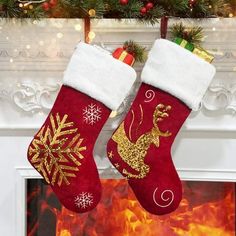 two christmas stockings hanging from a fireplace with fire in the background and decorations on it