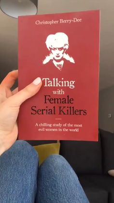 a person holding up a red book with the title talking with female serial killers