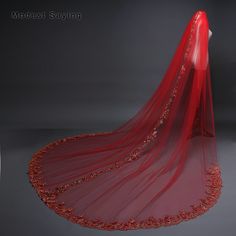 a red wedding dress with long veil on display