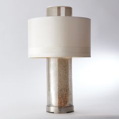 a table lamp with a white shade on it's base and a silver metal base