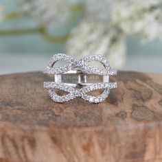 a close up of a ring on top of a wooden surface with flowers in the background