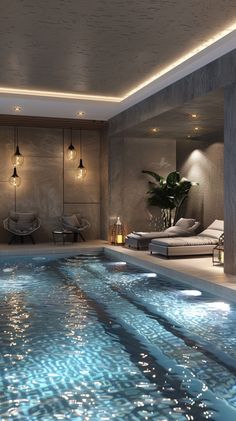 an indoor swimming pool with lounge chairs and lights on the ceiling, next to a bed