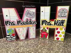 three school signs are sitting on the counter in front of a tile backsplash