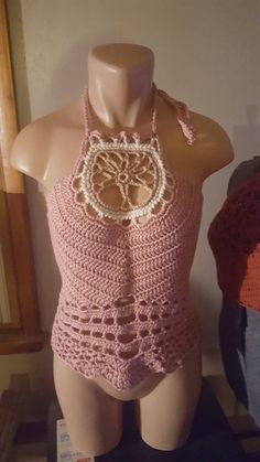 a female mannequin wearing a pink crocheted halter top