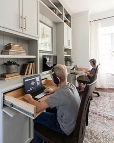 a man sitting at a desk with a laptop and headphones in front of him