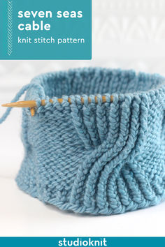 a knitted basket is shown with knitting needles in the middle and on top of it