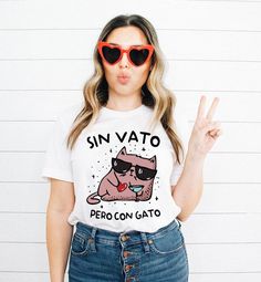 Sin vato pero con gato shirt, Valentines gift, Spanish gift, Dia de San Valentin, Latina shirt, Latina gift, Spanish Valentines, Español This classic unisex jersey short sleeve tee fits like a well-loved favorite. Soft cotton and quality print make users fall in love with it over and over again. These t-shirts have-ribbed knit collars to bolster shaping. The shoulders are tapered for a better fit over time. Dual side seams hold the garment's shape for longer.  .: Made with 100% Airlume combed an Funny White Tops As Gifts, White Novelty Tops As Gift, White Novelty Tops For Gifts, White Novelty Tops As A Gift, Novelty Letter Print Tops As Gift, Cute Graphic Print Shirt For Gift, Cute Graphic Print Shirt As Gift, Casual Shirt With Funny Text As Gift, Crew Neck Top With Cat Design For Gift