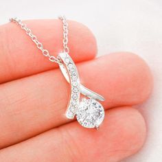 Melt her heart with this ALLURING BEAUTY necklace gift! The petite ribbon shaped pendant is finished with 14K white gold over stainless steel, and is embellished with dainty clear crystals surrounded by a sparkling 7mm round cut Cubic Zirconia. The adjustable cable chain allows the necklace to be worn at 18" to 22" in length. This necklace is one of our best sellers! Be sure to get yours NOW!Product Dimensions: • Height: 0.8" (20mm) x Width: 0.4" (10mm)• 7mm cubic zirconia • 18"-22" adjustable c Granddaughter Necklace, Wife Necklace, Bride Necklace, Beauty Necklace, Necklace Dress, Ribbon Necklace, Daughter Necklace, Biker Chick, Mors Dag