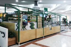 the inside of a fast food restaurant with green and white decor on the walls, along with tables and chairs