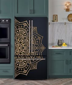 an intricately designed refrigerator in a kitchen with green cabinets and marble counter tops, along with wooden flooring