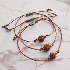 Handmade bracelet, crafted with care using a cotton brown cord, a sacred Rudraksha bead, and stainless steel beads. Embrace the powerful healing properties of Rudraksha, known for promoting tranquillity, clarity of mind, and positive energy. Elevate your spiritual journey and style with this unique and meaningful accessory, designed to bring harmony and balance to your life. 🚩 Bracelet is well-suited for both women and men, ensuring a comfortable fit for a wide range of wrist sizes, with a maxi Adjustable Brown Bracelet For Festivals, Adjustable Brown Bracelets For Festivals, Adjustable Bohemian Bracelets For Puja, Spiritual Waxed Cord Bracelets As Gift, Spiritual Waxed Cord Bracelets For Gift, Adjustable Spiritual Friendship Bracelets For Festivals, Spiritual Waxed Cord Bracelets With Round Beads, Brown Spiritual Braided Bracelets For Friendship, Brown Hand-strung Friendship Bracelets With Round Beads