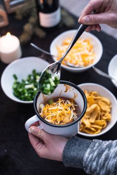 a person is spooning food out of a bowl with other dishes in the background