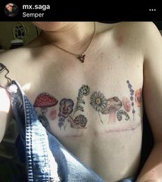 a woman with tattoos on her chest holding a cell phone