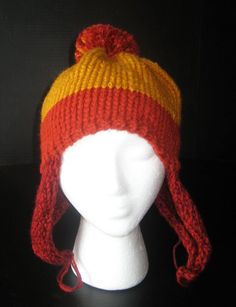 a white mannequin head wearing a red and yellow knitted hat