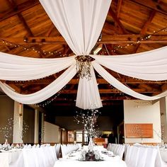 the tables are covered with white linens and draping