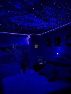 a bedroom with blue lighting and stars on the ceiling