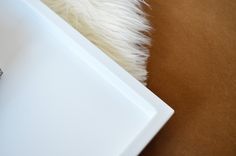 a close up of a cell phone on a white tray with fur in the background