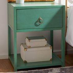 a green nightstand with two boxes on it