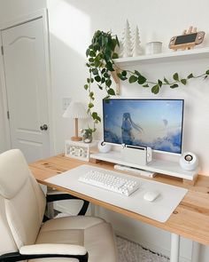 a desk with a computer, keyboard and mouse on it in front of a potted plant