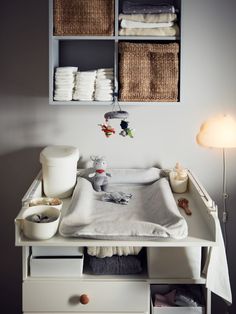 a baby's crib in the corner of a room with baskets on it