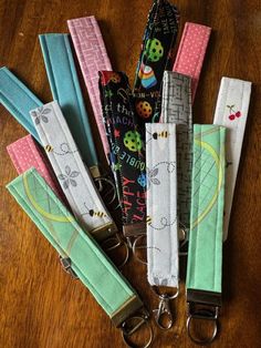 several lanyards are lined up on a table with keychains attached to them