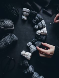 someone is knitting yarn together in a circle on a table with crochet hooks