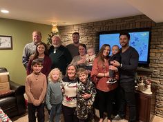 a group of people standing in front of a tv with a christmas tree on it