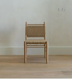 a wooden chair sitting on top of a hard wood floor next to a white wall