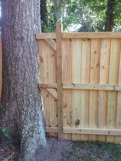 a wooden fence is next to a tree