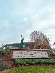 the university of alabama sign is in front of a brick building with a statue of an antelope on it