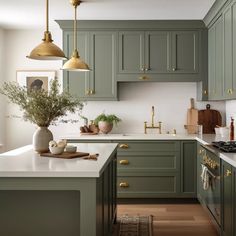 a kitchen with green cabinets and white counter tops, gold hardware on the handles and brass knobs