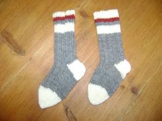 two pairs of socks sitting on top of a wooden floor