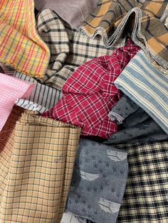 a pile of different colored shirts sitting on top of each other