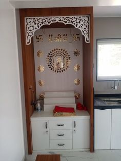 a kitchen area with white cabinets and gold decorations on the wall, along with a wooden table