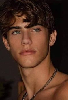 a close up of a young man wearing a chain around his neck and shirtless chest