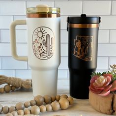 two coffee mugs sitting next to each other on top of a wooden table with beads