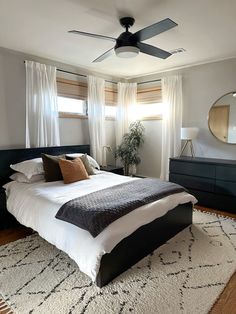 a bedroom with a bed, dressers and ceiling fan in it's center