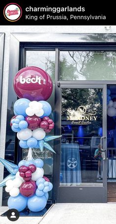 balloons are in front of the door of a building that has been decorated with blue, white and pink balloons